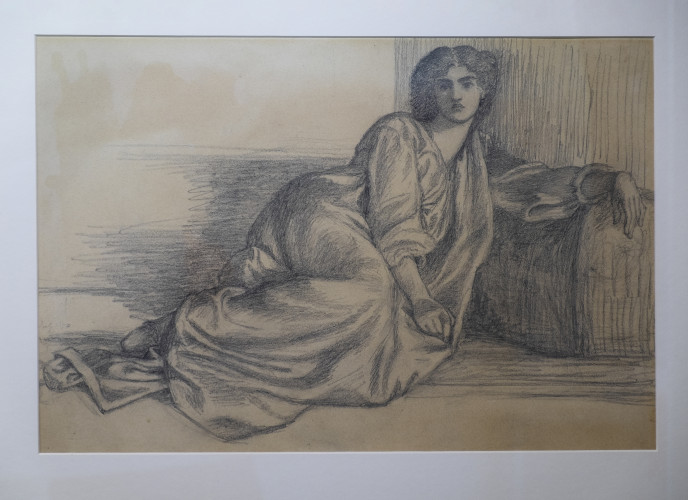 A woman is seated on a large sofa looking out at the viewer