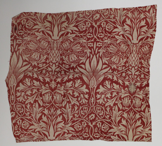 Square fabric sample with a floral design in shades of red.