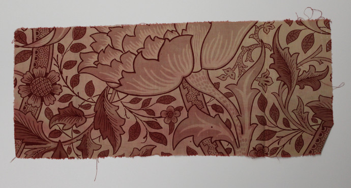 Fabric fragment featuring twisted stems and large elaborate flowers in shades of red.