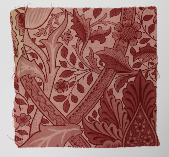 Fabric fragment featuring twisted stems and large elaborate flowers in shades of red.