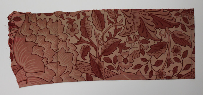 Fabric fragment featuring twisted stems and large elaborate flowers in shades of red.