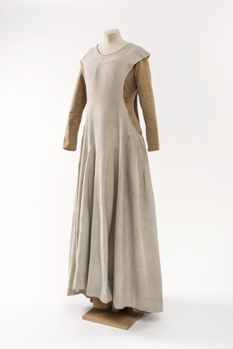 A cream coloured medieval style gown with open sides by the arms