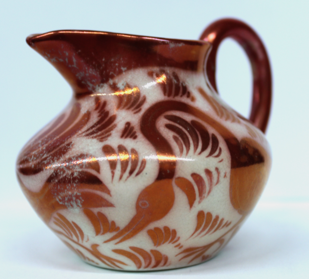 Painted in a red lustre with a design of birds